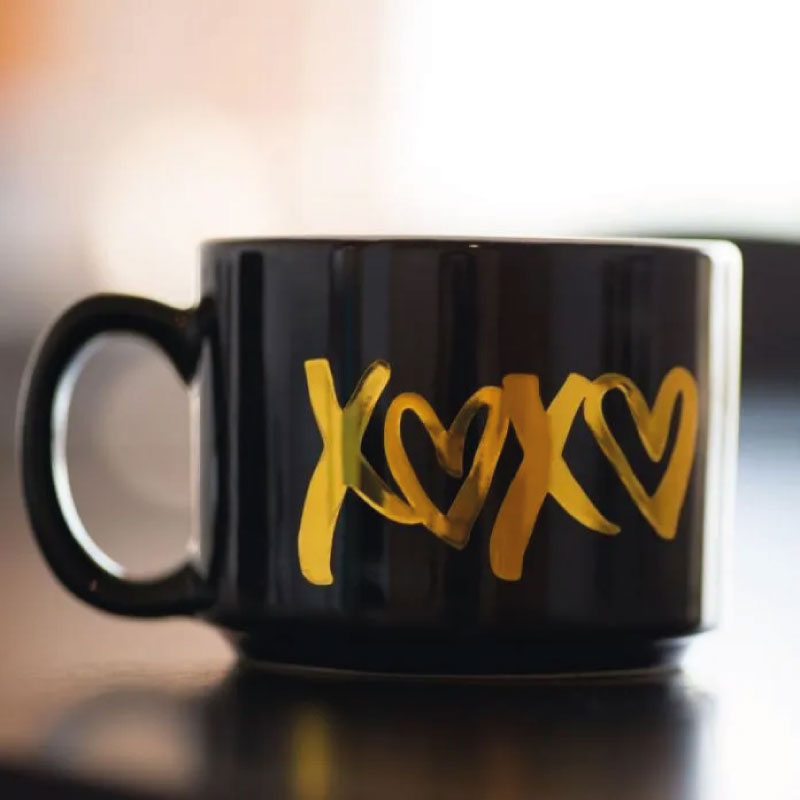 Tasse dekoriert mit metallic-goldener Folie. Quelle: Silhouette Foto 1: Vinylrolle auf einer Silhouette-Schneidemaschine platziert. Quelle: Silhouette