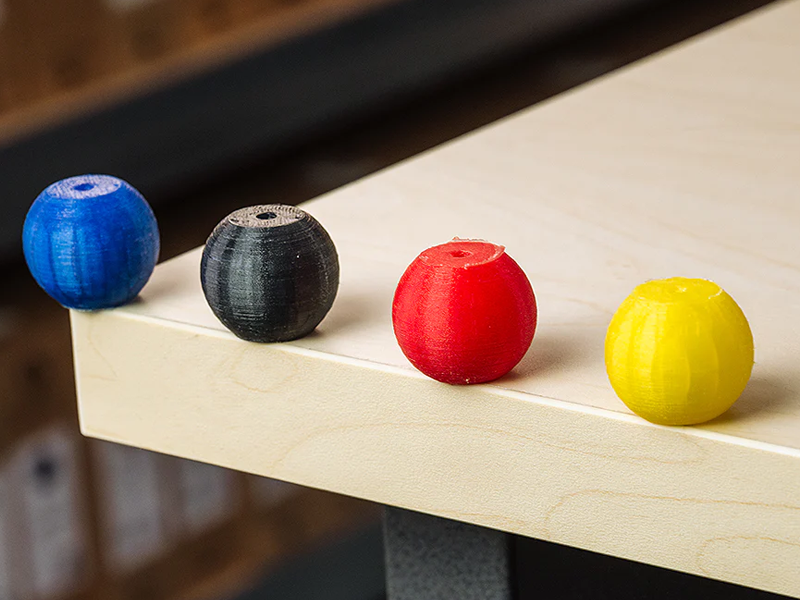 Peças impressas em 3D com Flexfill PEBA 90A em azul, preto, vermelho e amarelo